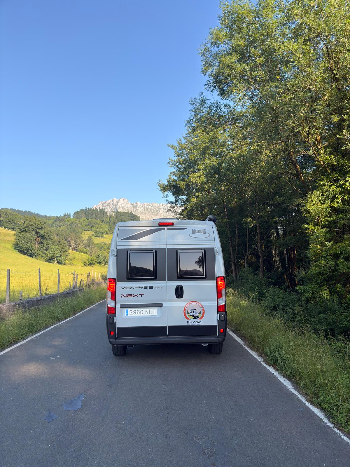 Camper BiziVan McLouis Menfys 3 Maxi en carretera con el monte al fondo en Bizkaia