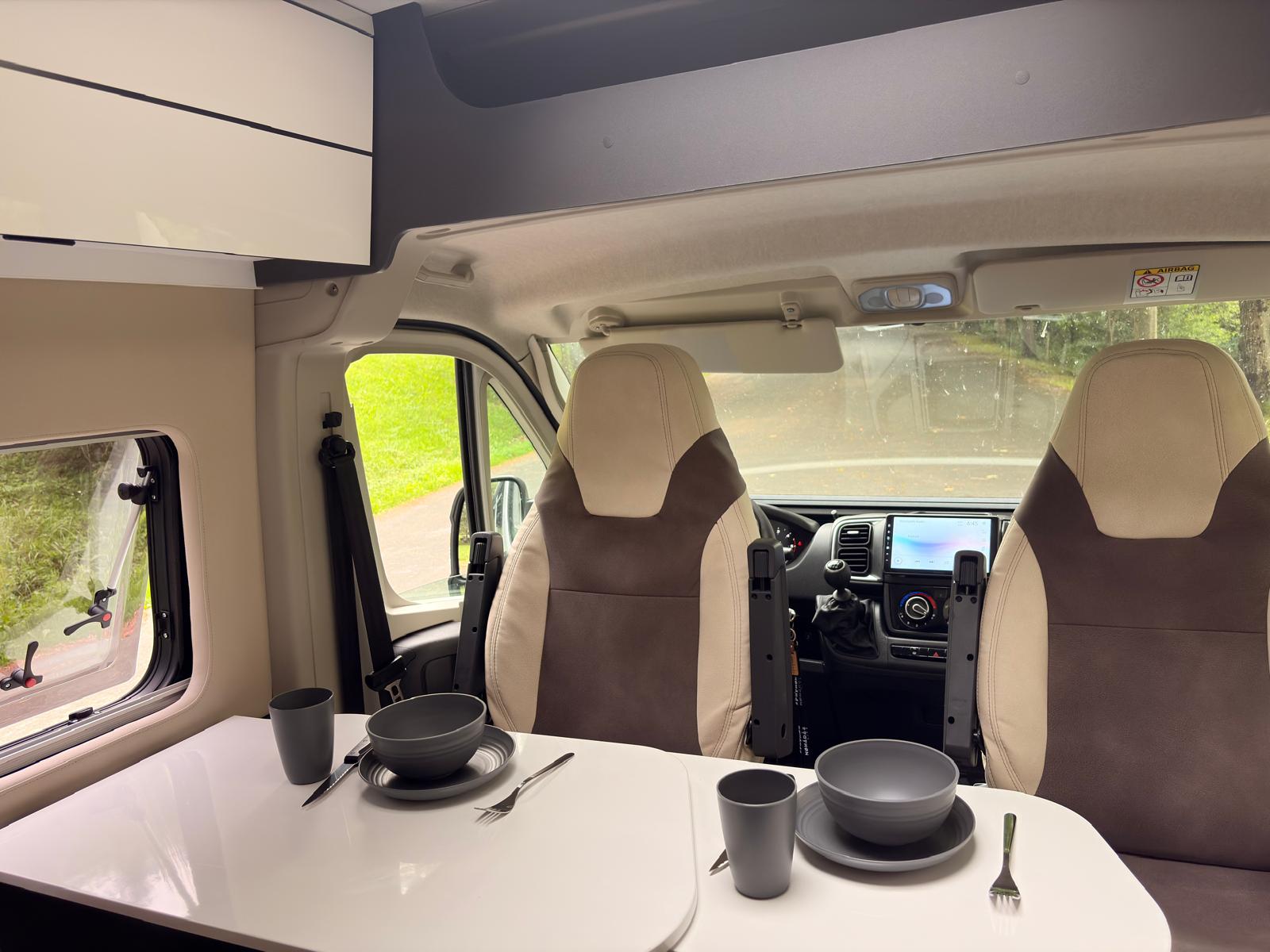 Mesa puesta en el interior de la camper BiziVan con asientos giratorios